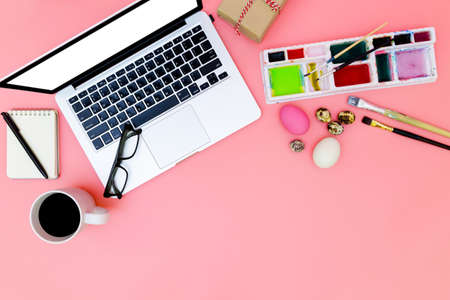 flat lay photo of modern workplace with laptop and eggs, top view laptop background and paint set preparing for Easter on pink background, easter eggsの写真素材