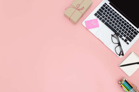 Flat lay office workspace with blank laptop, clipboard, eucalyptus branches on pink background. top view laptop background and copy space on pink background, Above view shot of laptop background, Laptop backgroundの写真素材