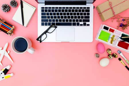 flat lay photo of modern workplace with laptop and eggs, top view laptop background and paint set preparing for Easter on pink background, easter eggsの写真素材