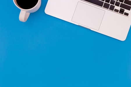 flat lay Office desk table of modern workplace with laptop on blue table, top view laptop background and copy space on blue background, blue desk office with laptop, smartphone and other work suppliesの写真素材