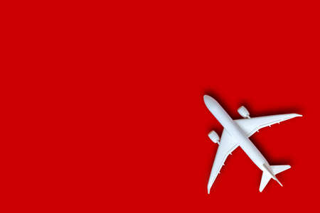 Model plane, airplane on red color background with copy space, Flat lay design with white plane, Travel concept on red background. top view model white plane on red color background.の写真素材