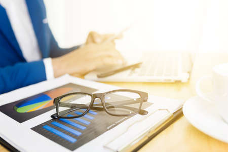 Business accounting plan concept, Working on desktop laptop computer with calculator for making business, business man hand working with laptop computer on wooden desk business investment advisor.の写真素材