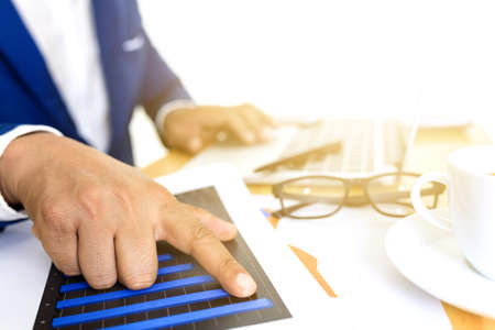 Business accounting plan concept, Working on desktop laptop computer with calculator for making business, business man hand working with laptop computer on wooden desk business investment advisor.の写真素材