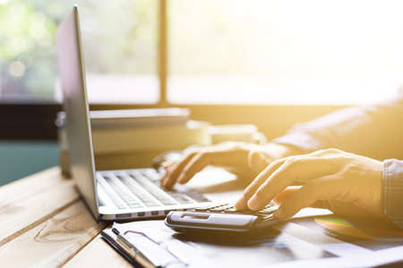 Office desk table of modern workplace with laptop on wooden table, top view laptop background and copy space on wooden background, White desk office with laptop, smartphone and other work supplies on wood desk, laptop backgroundの写真素材
