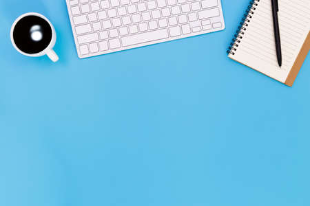 flat lay Office desk table of modern workplace with laptop on blue table, top view laptop background and copy space on black background, blue desk office with laptop, smartphone and other work supplies with mouse.の写真素材