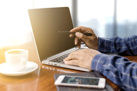 businessman working with modern workplace with laptop on wood table, Man hand on laptop keyboard for...