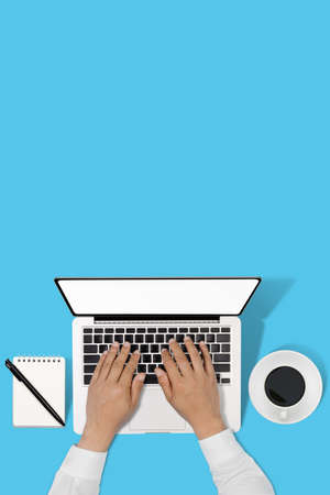 businessman working with modern workplace with laptop on blue table, Man hand on laptop keyboard for work from home, Overhead view of businessman working  in officeの写真素材
