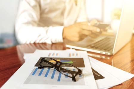businessman working with modern workplace with laptop on wood table, Man hand on laptop keyboard for work from home, Overhead view of businessman working  in officeの写真素材