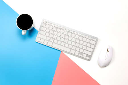 flat lay Office desk table of modern workplace with laptop on blue pink and white background, top...
