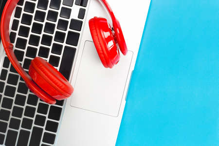 a red headphones, Top view of red headphones with laptop keyboard on blue and white background. Minimalist photo of earphones with copy space. red dj headphones,の写真素材