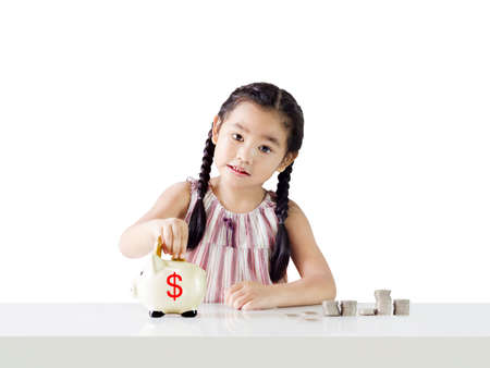 Asian little girl saving money in a piggy bank,education and money saving concept. Isolated on white backgroundの写真素材