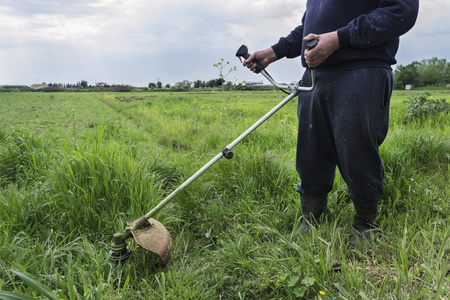 Man working with a lawn mower trimmer