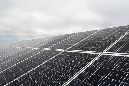 Field with many solar panels in front of a blue sky