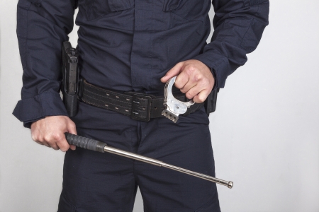 Policeman with gun, handcuff and iron batonの写真素材