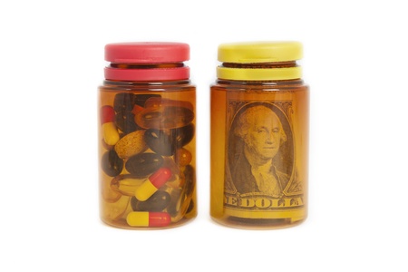 pill bottles with money and pills on white backgroundの写真素材