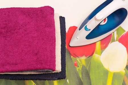 Electric iron and towels on ironing boardの写真素材