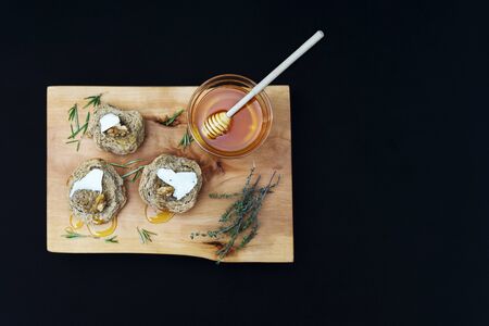 Jar with organic honey, butter, nut and walnut on a wood and black backgroundの写真素材