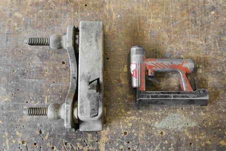 Old used wooden planer and red air nailer or nail gun, carpenter toolsの写真素材