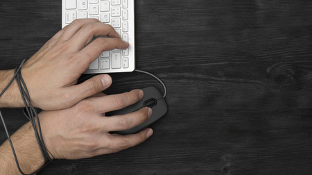 Hands  of man addicted to computer, internet slave and addict conceptの写真素材