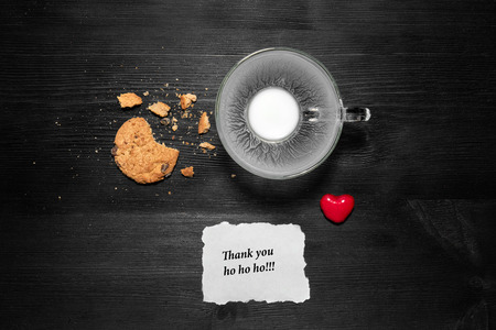 Cookies and milk for Santa Clause on black wooden backgroundの写真素材