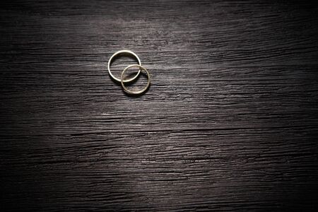 couple of gold wedding rings on black backgroundの写真素材