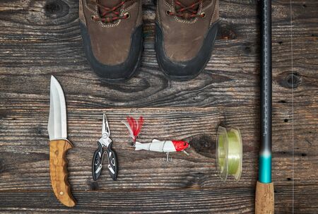 fishing tackles and fishing gear on wooden background, top viewの写真素材