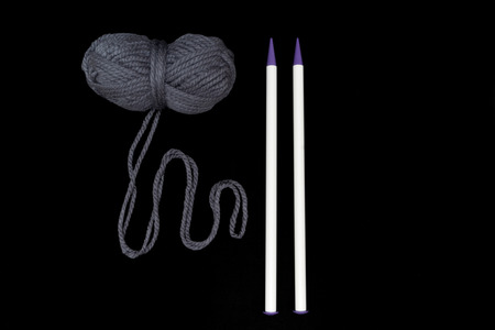 Ball of yarn with knitting needles isolated on black backgroundの写真素材