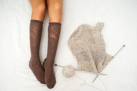 photo of woman on the bed with yarn and knitting needlesの写真素材