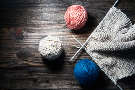 Balls of yarn with knitting needles isolated on wooden backgroundの写真素材