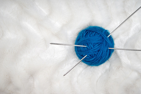 Ball of yarn with knitting needles isolated on white background