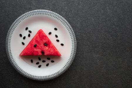 Watermelon on vintage plate on black marble background