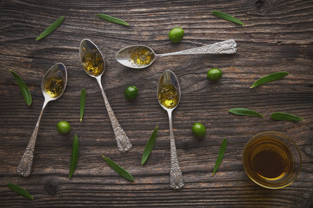 ?live oil in  vintage spoon on wooden backgroundの写真素材