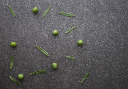 Olive oil in vintage spoons on black marbleの写真素材