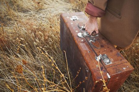 Close up of man hands holding vintage suitcaseの写真素材