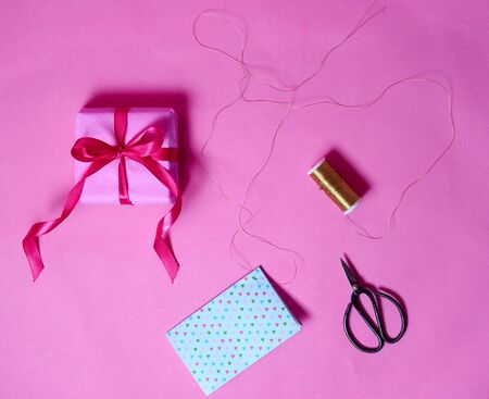 Box gift, gold line and antique shears on pink background