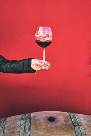 Winemaker getting sample of red wine from barrelの写真素材