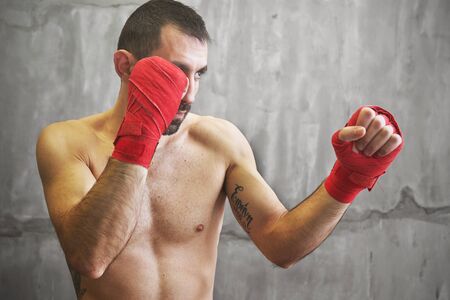Shot of wrapped hands  with red boxing tape of young boxer fighterの写真素材