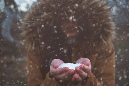 Girl blowing snow in the forestの写真素材