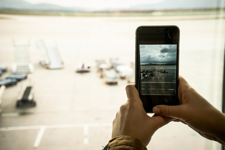 Girl taking a photograph of the airportの写真素材
