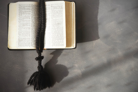 Bible and rosary on a cement background.の写真素材