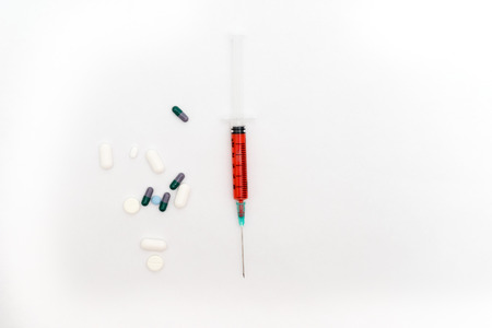 Medical syringe and pills isolated on white backgroundの写真素材