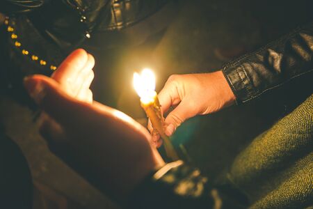Woman holding a candle at night, during the Easter celebrationsの写真素材