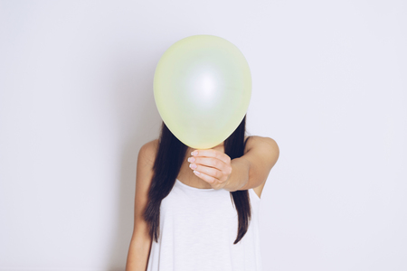 Woman holds balloons in a white backgroundの写真素材