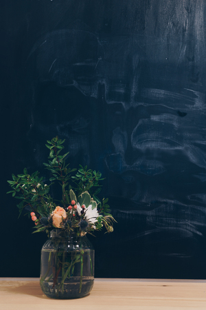 Workplace, study, room with table and blackboard, with flowers.の写真素材