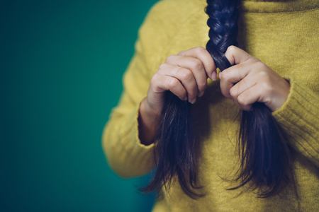 Girl is plaiting her hair