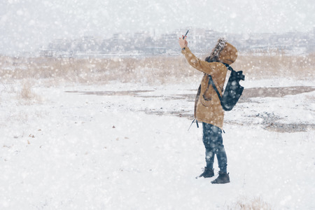 woman is taking photo in snowy landscapeの写真素材