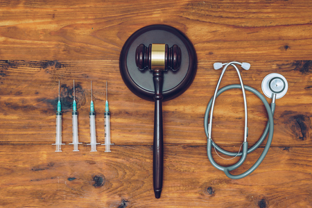 Syringes, stethoscope and  judge gavel on wooden background.の写真素材