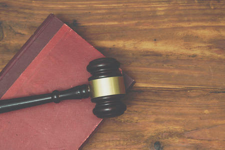 Gavel and law book on a wooden background
