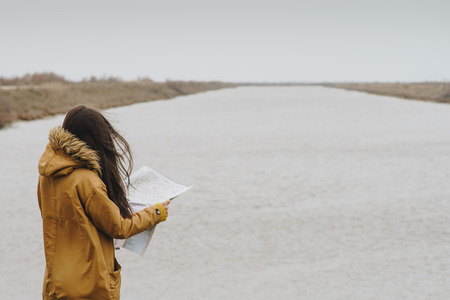 Woman reading a map next to a river, Greece.の写真素材