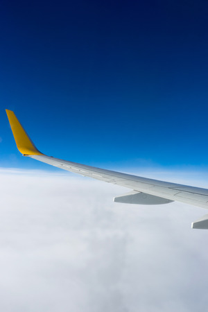 Clouds and wing, view from the window of airplane flying in the cloudsの写真素材